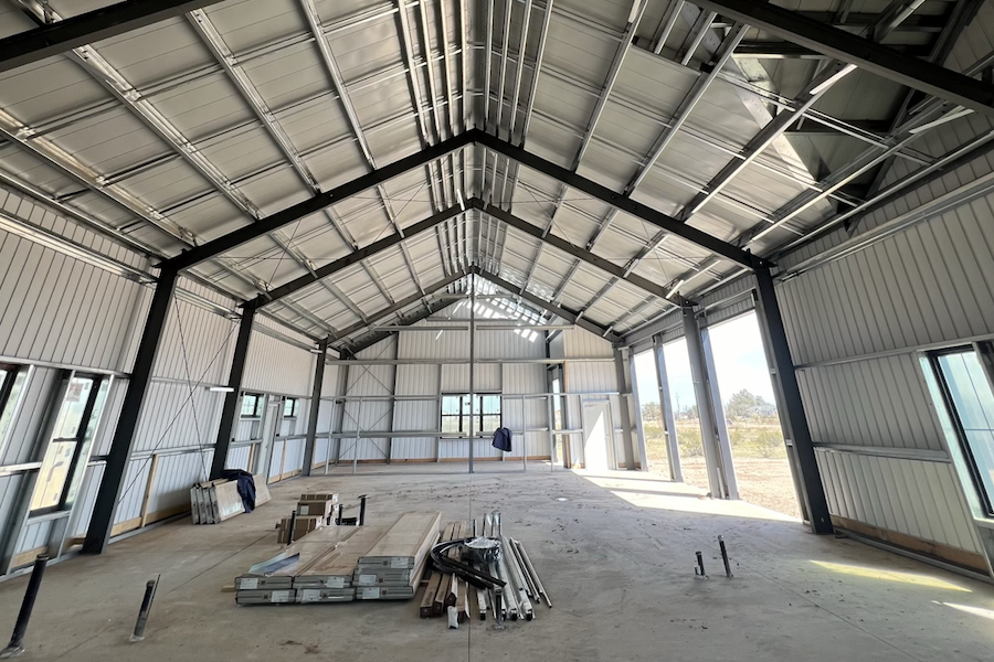 interior large building retail space, poured concrete floors, wood and steel roof interior beams