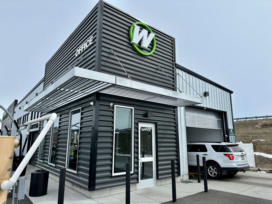 exterior modern steel retail structure with vibrant green and white logo branding for Wicked Wash